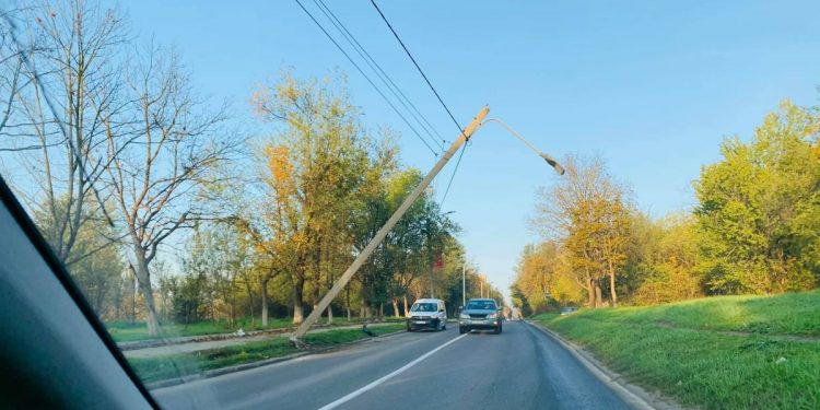 Un pilon, suspendat pe câteva linii electrice, stă să cadă pe o stradă din Chișinău