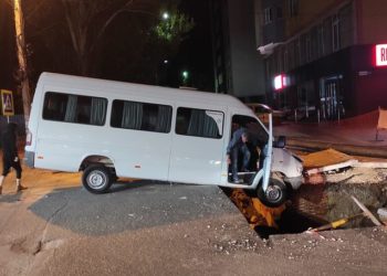 Un microbuz a ajuns blocat într-o groapă formată în mijlocul străzii