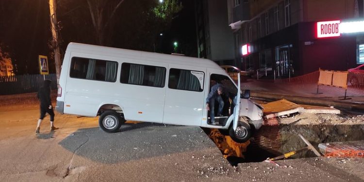 Un microbuz a ajuns blocat într-o groapă formată în mijlocul străzii