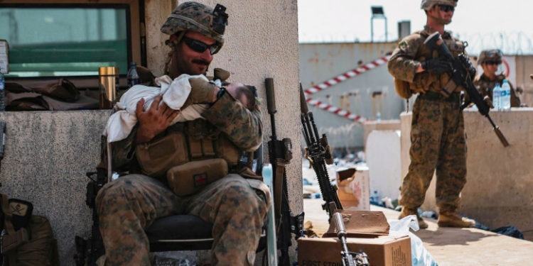 „Salvaţi-mi copilul!” Imaginile virale cu militarii SUA care au grijă de copiii afgani în haosul din aeroportul din Kabul | FOTO