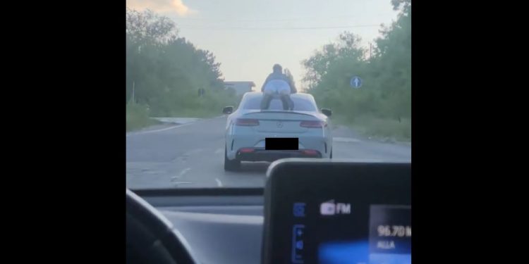 Moment periculos în trafic: Un tânăr a fost filmat deplasându-se pe acoperișul unui automobil | VIDEO