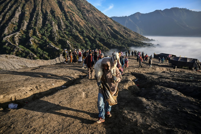 Ritual de sacrificare la vulcanul activ Bromo din Indonezia. Mii de oameni aruncă animale și alimente în crater | FOTO