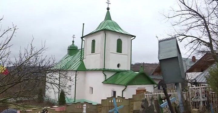Scandalul de la biserica din Dereneu ia amploare: în genunchi, pe ger, oamenii se roagă înconjurați de poliție